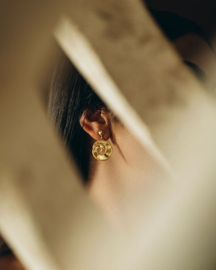 Gold earring with a round stone